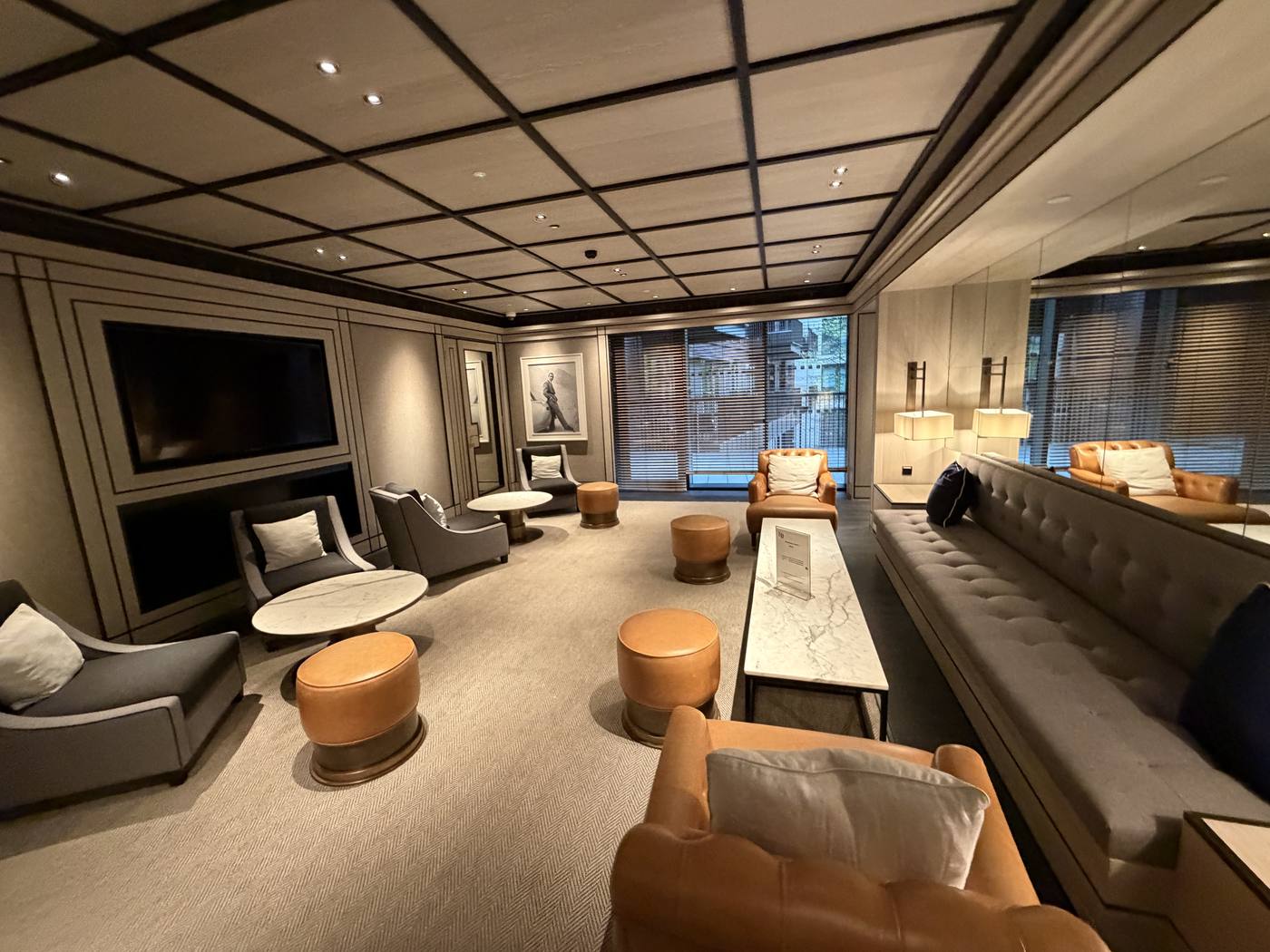 A lounge with leather sofas, armchairs and soft lighting